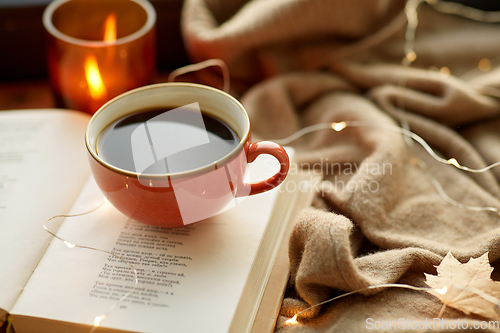 Image of cup of coffee, book on window sill in autumn