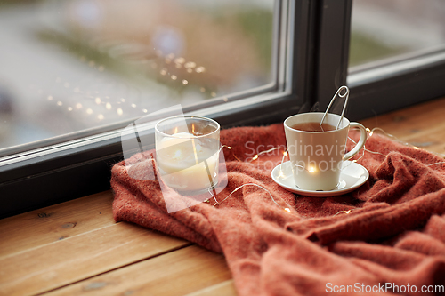 Image of cup of tea and candle on window sill