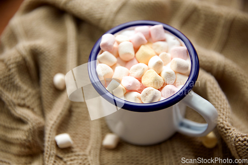 Image of camp mug full of marshmallow on knitted blanket