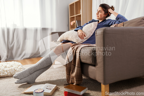 Image of woman with pillow and books on floor at home