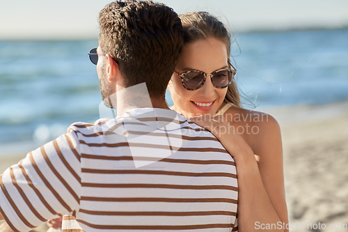 Image of happy couple hugging on summer beach