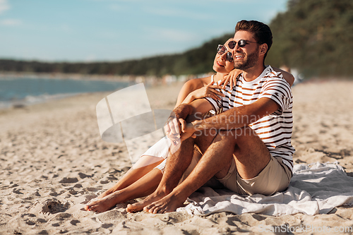 Image of happy couple chilling on summer beach