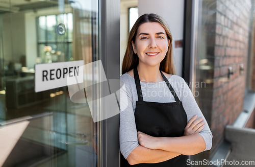 Image of happy woman with reopen banner on door glass