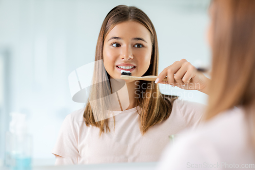 Image of teenage girl with toothbrush brushing teeth