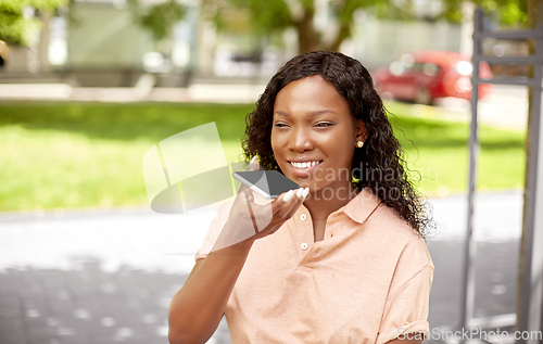 Image of african woman recording voice on smartphone