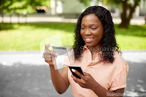 Image of african woman with smartphone and credit card
