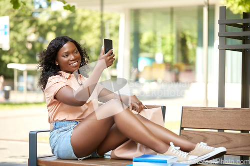Image of african student girl taking selfie with smartphone