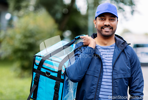 Image of happy smiling indian delivery man with bag in city