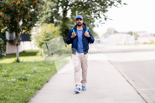 Image of indian delivery man with bag walking in city