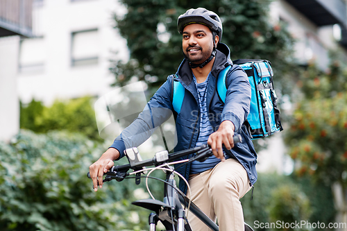 Image of indian delivery man with bag riding bicycle