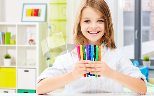 Image of smiling student girl with felt-tip pens at home