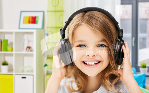 Image of happy smiling girl with headphones at home