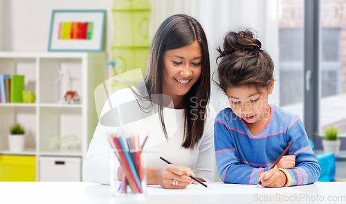 Image of happy mother and daughter drawing at home