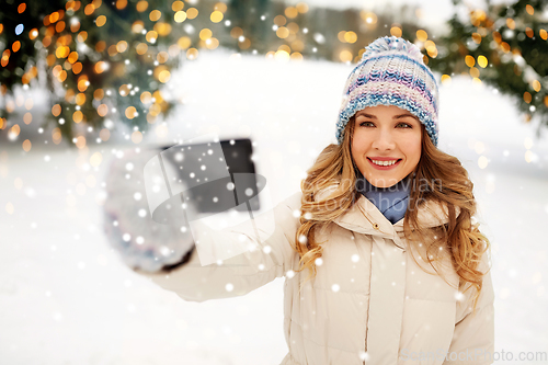 Image of woman taking selfie by smartphone in winter