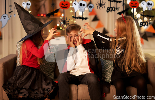 Image of kids in halloween costumes playing at home