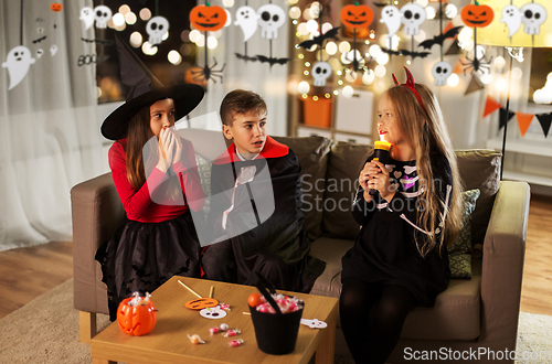 Image of kids in halloween costumes playing at home