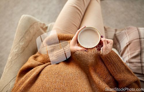 Image of woman in sweater holding mug of hot chocolate