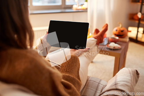 Image of woman with tablet pc at home on halloween