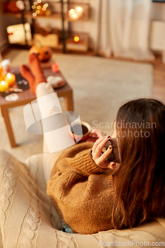 Image of woman calling on smartphone at home on halloween