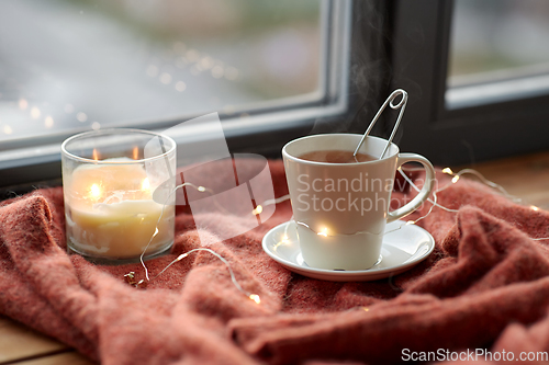 Image of cup of tea and candle on window sill