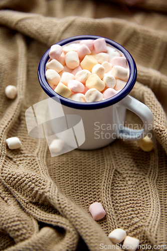 Image of camp mug full of marshmallow on knitted blanket