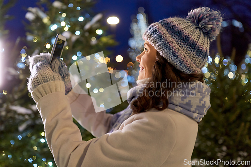 Image of woman with smartphone taking christmas selfie