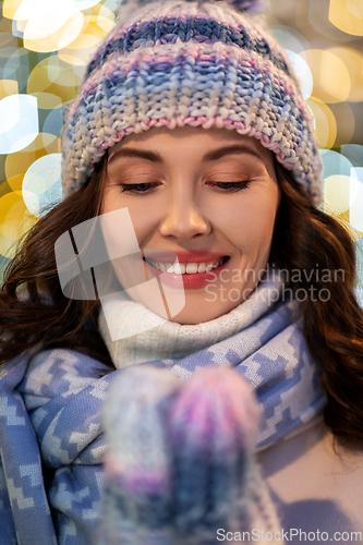 Image of portrait of happy young woman in christmas lights