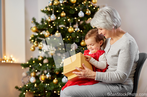 Image of grandmother and baby girl with christmas gift