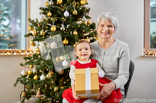 Image of grandmother and baby girl with christmas gift