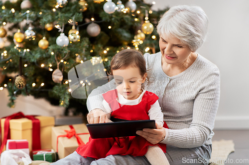 Image of grandmother and baby girl with christmas gifts