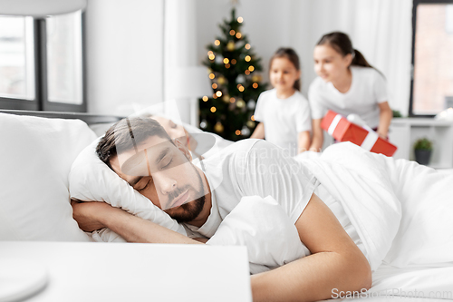 Image of happy children wake their parents on christmas