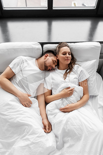 Image of happy couple sleeping in bed at home