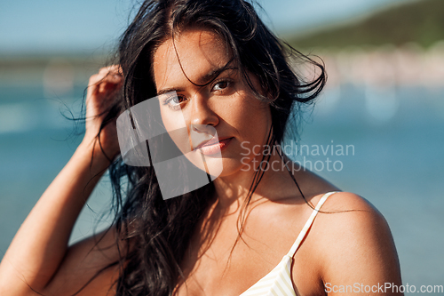 Image of young woman in bikini swimsuit on beach