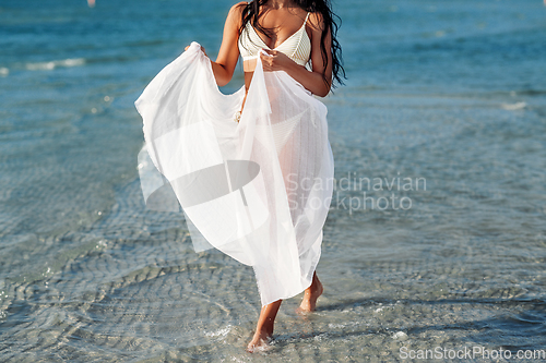 Image of woman in bikini swimsuit with cover-up on beach