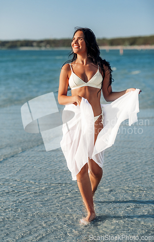 Image of woman in bikini swimsuit with cover-up on beach