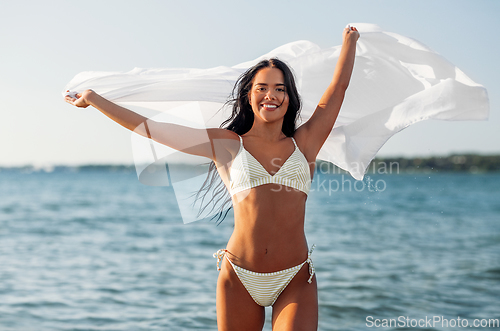 Image of woman in bikini swimsuit with cover-up on beach