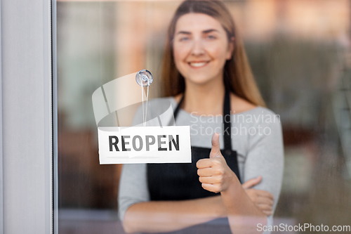 Image of woman with reopen banner on door showing thumbs up