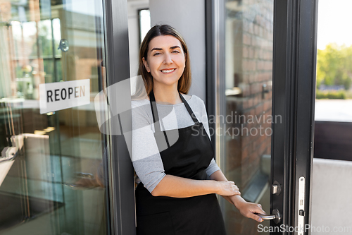 Image of happy woman with reopen banner on door glass