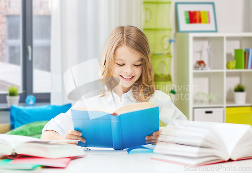 Image of happy smiling student girl reading book at home