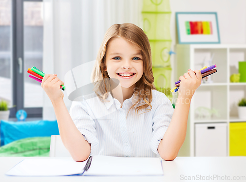 Image of smiling girl with colorful felt-tip pens at home