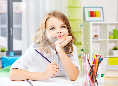 Image of happy girl drawing with pencils at home