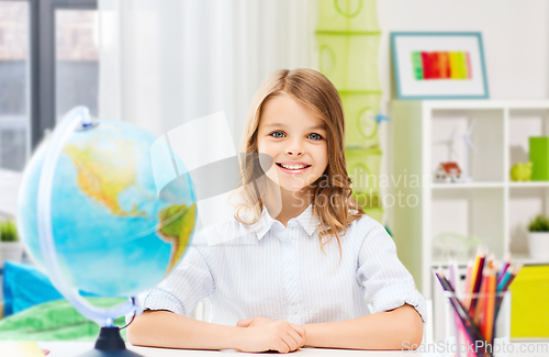 Image of happy smiling student girl with globe at home