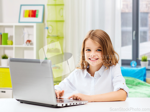 Image of smiling student girl with laptop computer at home