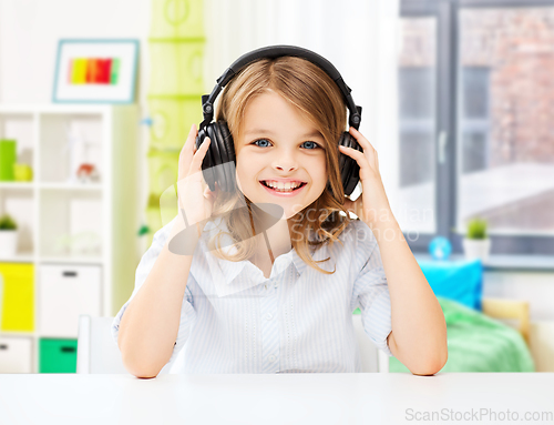 Image of happy smiling girl with headphones at home