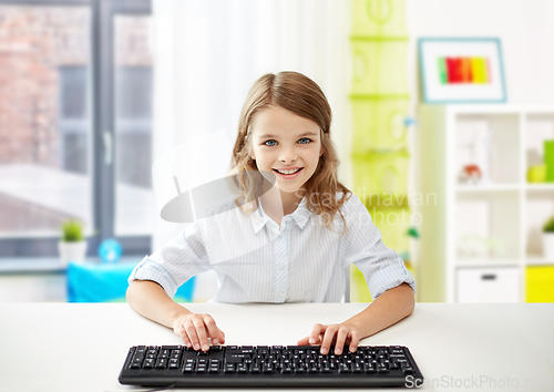 Image of happy student girl with keyboard at home