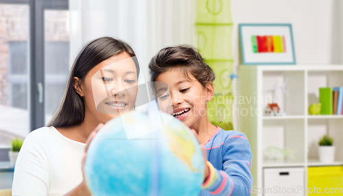 Image of mother and daughter with globe at home
