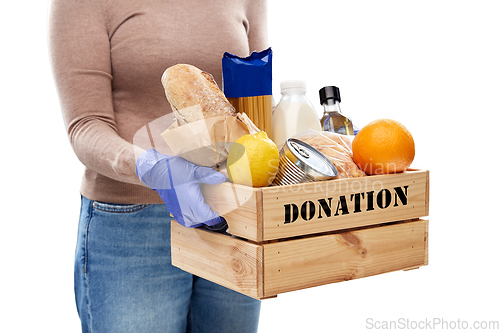 Image of woman in gloves with food donation in wooden box