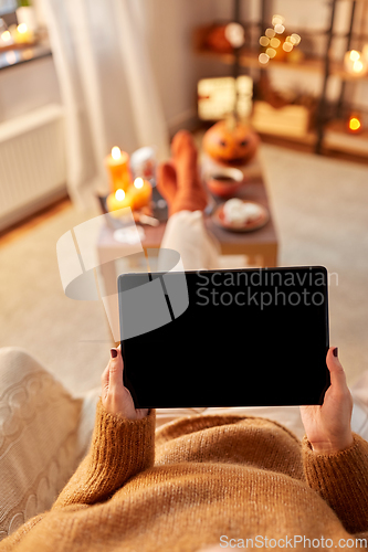 Image of woman with tablet pc at home on halloween