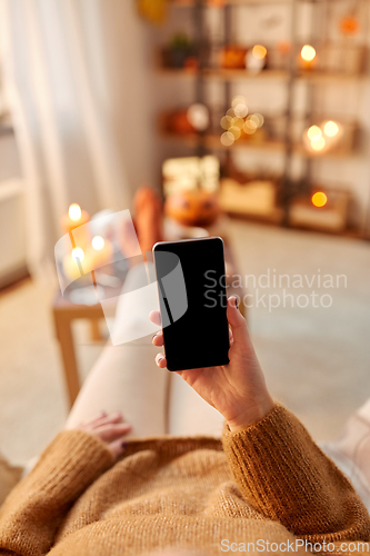 Image of woman using smartphone at home on halloween