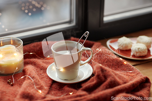 Image of cup of tea and candle on window sill